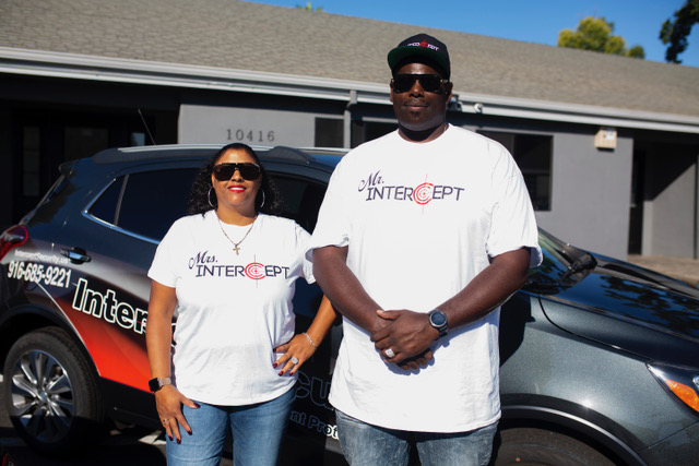 Intercept Security Co-Founder Margarita Holman and Founder and CEO David Holman standing in front of a company car