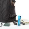 Personal Pepper Spray - Blue next to backpack, pens and notebook for size