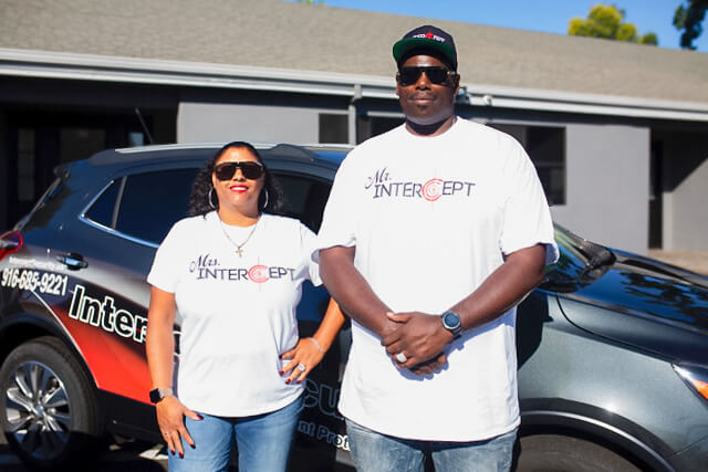 Intercept Security Co-Founder Margarita Holman and Founder and CEO David Holman standing in front of a company car